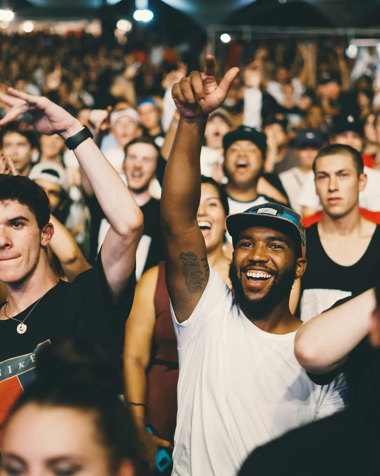 An excited crowd cheering with their hands in the air