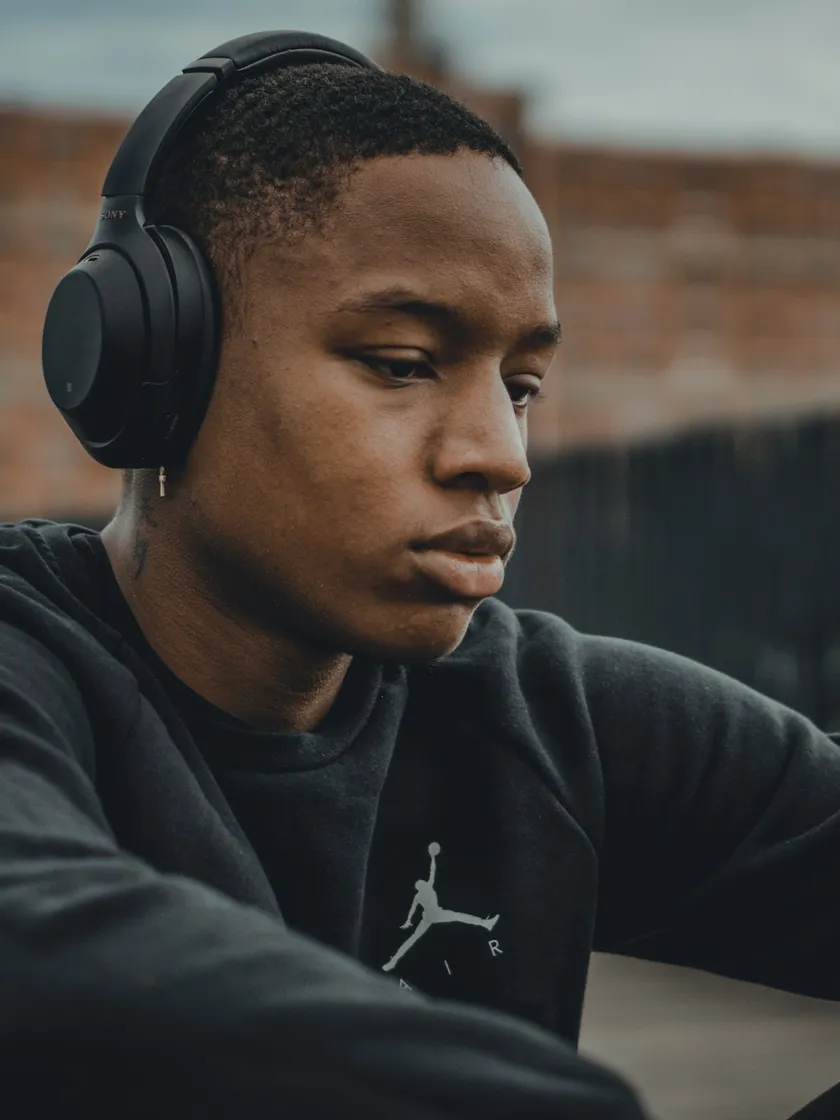 A young man in headphones listening on his phone